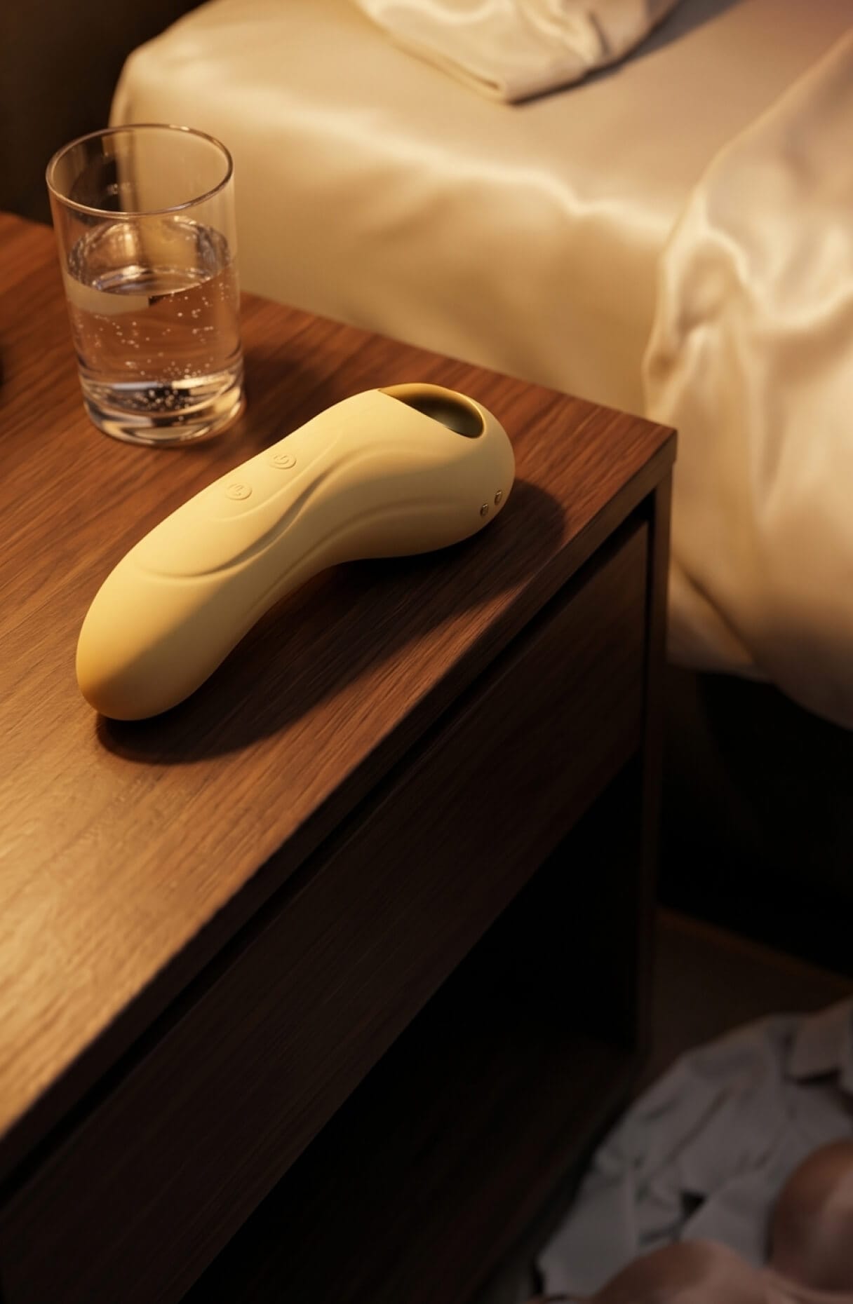 A vibrator and glass of water on a nightstand